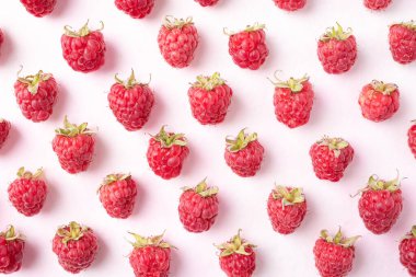 Taze olgun ahududu, pembe arka planda yaprak, yaz meyvesi, Top view