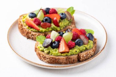 Çilekli, yabanmersinli, ahududulu ve üzümlü avokado tostu. Sağlıklı beslenme