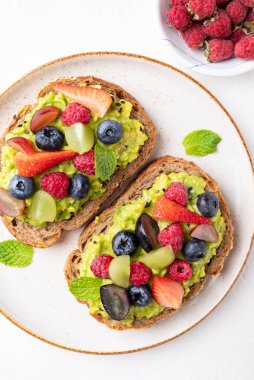 Çilekli, böğürtlenli, ahududulu ve üzümlü avokado tostu. Sağlıklı beslenme