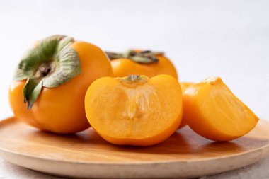 Tahta tabakta taze olgun hurma, sonbahar tatlı meyvesi