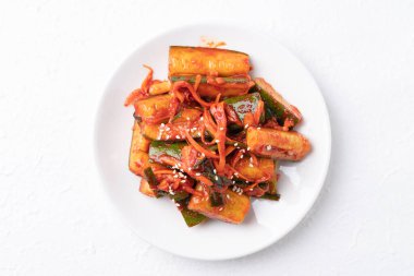 Beyaz tabakta Kore kimchi salatalığı Kore mezesi, ev yapımı yemekler.