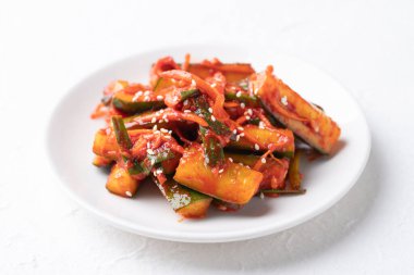Beyaz tabakta Kore kimchi salatalığı, Kore mezesi, ev yapımı yemek.