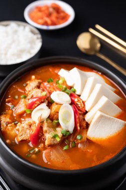 Kore yemeği (Kimchi Jjigae), kimchi çorbası tofu, domuz eti, soğan ve biber Kore taş kasesinde pilav ve taze kimchi ile yenir.