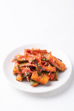 Beyaz tabakta Kore kimchi salatalığı, Kore mezesi, ev yapımı yemek.
