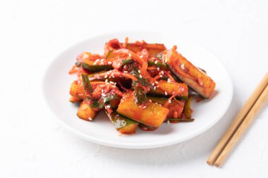 Kore kimchi salatalığı beyaz tabakta yemek çubukları, Kore mezesi, ev yapımı yemekler.