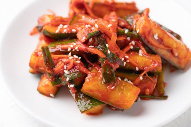 Beyaz tabakta Kore kimchi salatalığı, Kore mezesi, ev yapımı yemek.