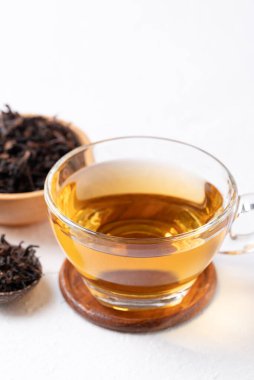 Beyaz arka planda kurutulmuş çay yaprakları, sağlıklı bitkisel sıcak içecek.