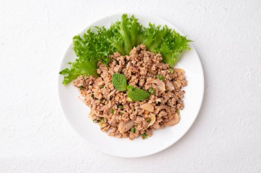 Beyaz arka planda yerel Tayland yemeği, baharatlı kıymalı domuz salatası (Larb Moo), Top view