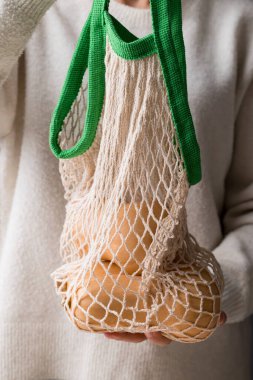 Kabak kabağı kadın eliyle tutulan ağ torbasında.