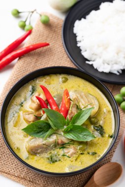 Tayland yeşil köri tavuğu, siyah kâse içinde pirinç ve malzemelerle.