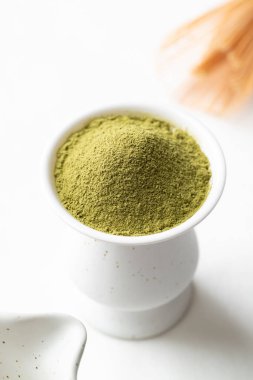 Bambu çırpmalı kibrit yeşil çay tozu ve beyaz arka planda Chawan kasesi.