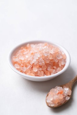 Himalaya pembe tuzu kasede ve kaşıkla beyaz arka planda, sağlıklı besin maddeleri