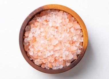 Himalaya pembe tuzu beyaz arka planda ahşap kasede, sağlıklı besin maddeleri