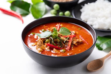 Domuz etli Tayland körisi ve beyaz arka planda malzemeli pilav.