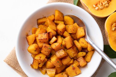 Kavrulmuş tereyağlı balkabağını kaşıkla bir kasede görmek, sonbahar ev yapımı yemekler.