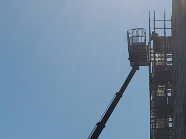 Workers working on a large building outdoors