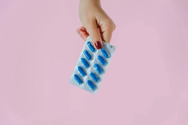 Nők Kéz Tartja Kék Kapszula Buborékcsomagolásban Rózsaszín Alapon Gyógyszerészet Orvostudomány Stock Kép