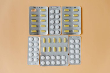 Medical equipment on the beige background. Blisters pills and capsules. Medical concept, flat lay.