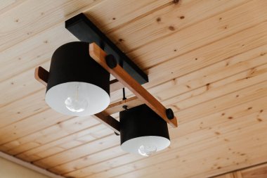 Interior details,ceiling. Stylish scandinavian composition of black bra and wooden walls. Loft style in modern home decor.