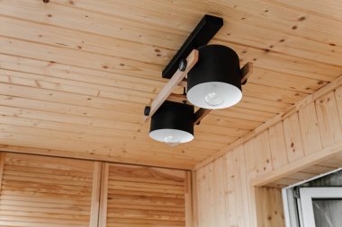 Interior details,ceiling. Stylish scandinavian composition of black bra and wooden walls. Loft style in modern home decor.