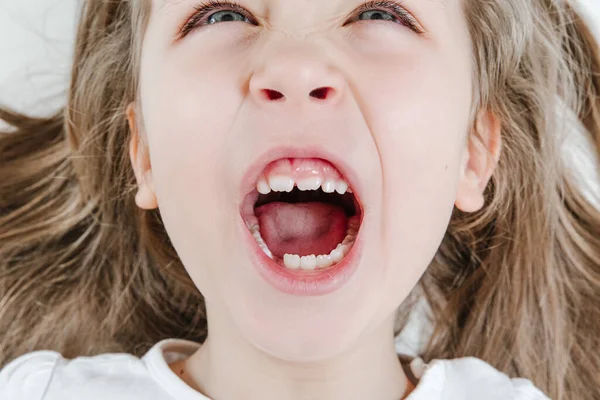 Happy smiling child portrait. Dental care, oral health. Close-up of teeth. Little todler attractive lovely sweet curious cheerful girl laughs with her teeth showing. White background