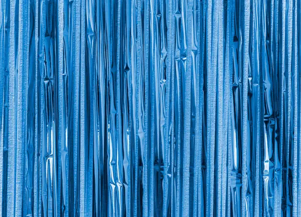 Mavi folyo şerit arka plan. Perde duvarda asılı. Şenlik, Noel, yeni yıl ya da yıldönümü partisi konsepti. Dekoratif duvar kağıdı