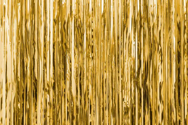 Sarı folyo şeridi soyut arkaplanı bulanıklaştırmış. Perde duvarda asılı. Şenlik, Noel, yeni yıl ya da yıldönümü partisi konsepti. Dekoratif duvar kağıdı