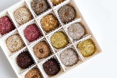 Bir kutu sağlıklı tatlı, doğal malzemelerden yapılmış şekerler. Vejetaryen organik yiyecekler. Beyaz arkaplan, üst görünüm