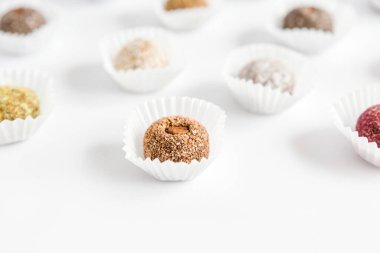 Bir kutu sağlıklı tatlı, doğal malzemelerden yapılmış şekerler. Vejetaryen organik yiyecekler. Beyaz arkaplan, yakın plan