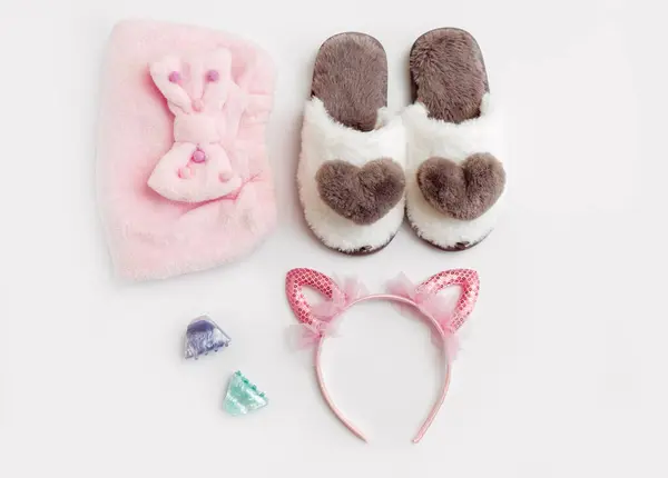 The hair cap, slippers, hair clips, hoop. Hair and grooming accessories for a girl. White background, flat lay