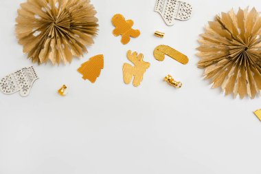 Noel dekorasyonu düzlüğü, Noel arkaplanı. Kağıt altın çelenkler, el yapımı Noel oyuncakları, beyaz arka plan, kopyalama alanı