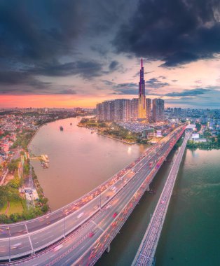 Ho Chi Minh city, Vietnam - 30 Aug 2022: Aerial sunset view at Landmark 81 - it is a super tall skyscraper and Saigon bridge with development buildings along Saigon river, cityscape in the night