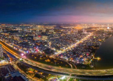 Ho Chi Minh city, Vietnam - 30 Aug 2022: Aerial view of a buildings with highway at night in Ho Chi Minh city, Vietnam. Background, cityscape and travel concept.