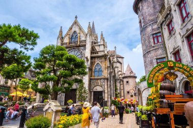 Da Nang, Vietnam - 12 Aug 2022: Many tourists on European style streets in Ba Na Hills Mountain Resort with amusement rides, attractions, restaurants.The famous tourist destination in Da Nang clipart