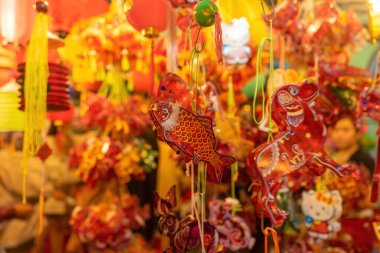 Decorated colorful lanterns hanging on a stand in the streets of Cholon in Ho Chi Minh City, Vietnam during Mid Autumn Festival. Chinese language in photos mean money and happiness. Selective focus.