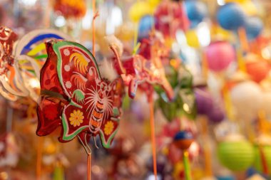 Decorated colorful lanterns hanging on a stand in the streets of Cholon in Ho Chi Minh City, Vietnam during Mid Autumn Festival. Chinese language in photos mean money and happiness. Selective focus.