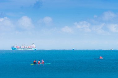 Vung Tau, Vietnam - 24 July 2022: people on paddle board surfboard surfing in ocean sea in Vung Tau beach, Vietnam. The Vung Tau city is popular among Ho chi minh city people as sea resort.