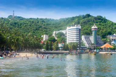 Vung Tau, Vietnam - 24 July 2022: People having rest on beach in Vungtau in sunset light. The Vung Tau city is popular among Ho chi minh city people as sea resort. Landscape and travel concept.