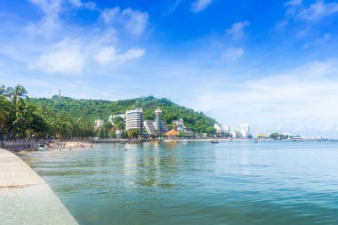 Vung Tau, Vietnam - 24 July 2022: People having rest on beach in Vungtau in sunset light. The Vung Tau city is popular among Ho chi minh city people as sea resort. Landscape and travel concept.