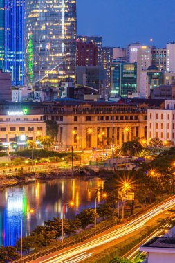 Ho Chi Minh city, Vietnam - 27 July 2022: Aerial view of Bitexco Tower, buildings, roads and Saigon river in Ho Chi Minh city - rush hour, many vehicles, motorcycle and car together on the road.