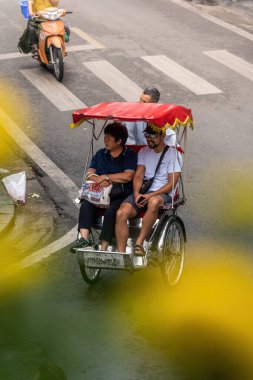 Hanoi, Vietnam - 08 Mayıs 2023: İnsanlar, satıcılar, bisikletler ve bisiklet sürücüleri eski Vietnam kasabası Hanoi 'de işlek, hareketli bir caddede turist alıyorlar. Vietnam 'ın ünlü hedefi