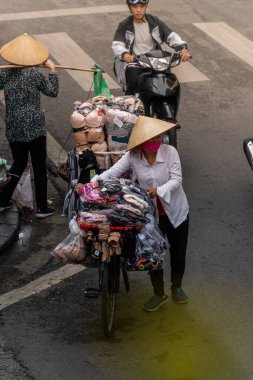 Hanoi, Vietnam - 08 Mayıs 2023: İnsanlar, satıcılar, bisikletler ve bisiklet sürücüleri eski Vietnam kasabası Hanoi 'de işlek, hareketli bir caddede turist alıyorlar. Vietnam 'ın ünlü hedefi