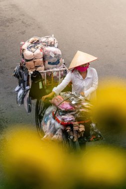 Hanoi, Vietnam - 08 Mayıs 2023: İnsanlar, satıcılar, bisikletler ve bisiklet sürücüleri eski Vietnam kasabası Hanoi 'de işlek, hareketli bir caddede turist alıyorlar. Vietnam 'ın ünlü hedefi