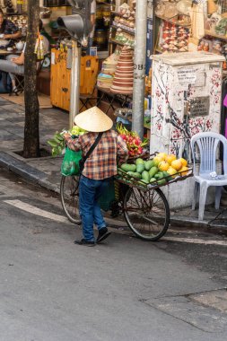 Hanoi, Vietnam - 08 Mayıs 2023: İnsanlar, satıcılar, bisikletler ve bisiklet sürücüleri eski Vietnam kasabası Hanoi 'de işlek, hareketli bir caddede turist alıyorlar. Vietnam 'ın ünlü hedefi