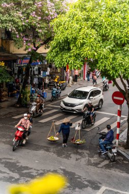 Hanoi, Vietnam - 08 Mayıs 2023: İnsanlar, satıcılar, bisikletler ve bisiklet sürücüleri eski Vietnam kasabası Hanoi 'de işlek, hareketli bir caddede turist alıyorlar. Vietnam 'ın ünlü hedefi