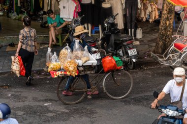 Hanoi, Vietnam - 08 Mayıs 2023: İnsanlar, satıcılar, bisikletler ve bisiklet sürücüleri eski Vietnam kasabası Hanoi 'de işlek, hareketli bir caddede turist alıyorlar. Vietnam 'ın ünlü hedefi
