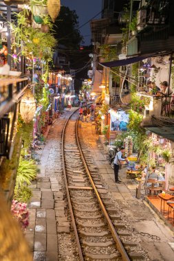 Hanoi, Vietnam - 08 Mayıs 2023: Hanoi Eski Mahallesi 'nin dar bir sokağından geçen tren görüntüsü. Turistler trenin resimlerini çekiyorlar. Hanoi Tren Sokağı popüler bir eğlencedir..