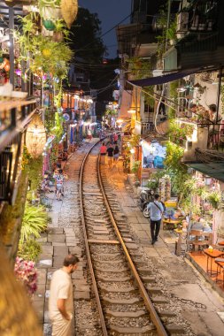 Hanoi, Vietnam - 08 Mayıs 2023: Hanoi Eski Mahallesi 'nin dar bir sokağından geçen tren görüntüsü. Turistler trenin resimlerini çekiyorlar. Hanoi Tren Sokağı popüler bir eğlencedir..