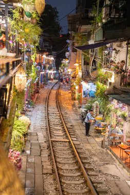 Hanoi, Vietnam - 08 Mayıs 2023: Hanoi Eski Mahallesi 'nin dar bir sokağından geçen tren görüntüsü. Turistler trenin resimlerini çekiyorlar. Hanoi Tren Sokağı popüler bir eğlencedir..