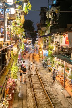 Hanoi, Vietnam - 08 Mayıs 2023: Hanoi Eski Mahallesi 'nin dar bir sokağından geçen tren görüntüsü. Turistler trenin resimlerini çekiyorlar. Hanoi Tren Sokağı popüler bir eğlencedir..